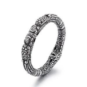 Vintage oxidized silver bracelet featuring intricate dragon relief and ethnic cloud patterns