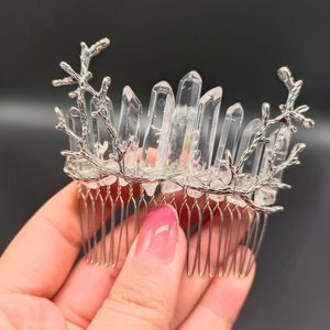 Close-up of a silver hair comb with crystal clusters on intricate branch design