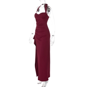 Detail view of burgundy halter neck maxi dress featuring side pleats and a high leg slit