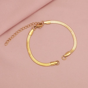 Dettaglio del bracciale a catena serpente dorata con chiusura a moschettone su rosa