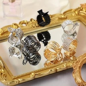 Elegant metal claw hair clips set with rhinestones and beads on a vintage mirror surface