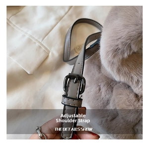 Détail de la bandoulière réglable en cuir gris avec boucle métallique sur sac en peluche