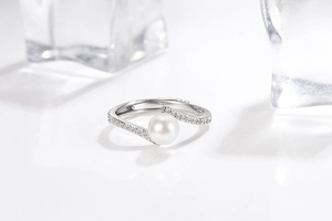 Detail of adjustable silver ring with white pearl and shimmering zircon stones