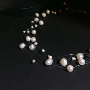 Collier multi-rangs en perles d'eau douce avec perles baroques sur fond noir élégant