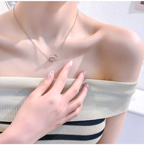 Close-up of elegant silver double heart necklace with sparkling crystals on female neck