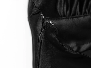 Détail d'une fermeture éclair invisible sur une robe dos nu noire en satin de soie