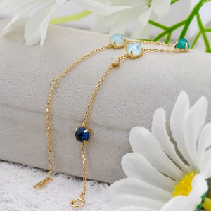 Macro detail of S925 silver gold chain with green chalcedony and colorful gemstones