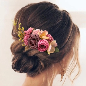 Detailed view of floral hair comb with dusty rose and burgundy roses on French updo