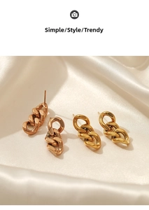 Detailansicht der Gliederketten-Ohrringe in Gold und Roségold auf weißer Seide