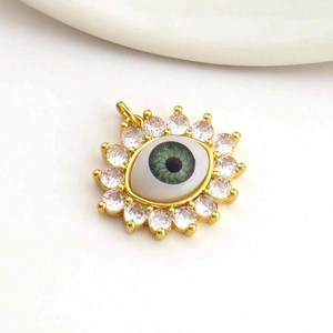 Detailed close-up of 18k gold plated evil eye pendant with green center and CZ crystals