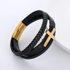 Close-up of multilayer braided leather bracelet with gold cross and magnetic clasp