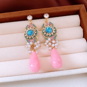 Detail of vintage bohemian earrings with pink water drop pendants and white pearls