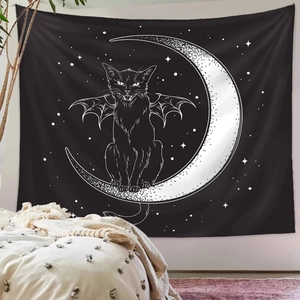 Detail of bohemian black tapestry with white cat and moon motif on a bedroom wall