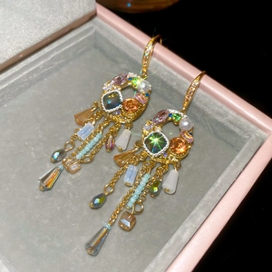 Detailed macro of vintage tassel earrings with colorful crystals and pearls in gold