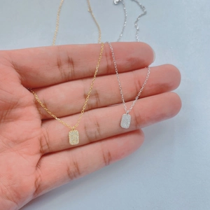 Macro detail of rectangle necklaces in gold and silver plating with zircon paving