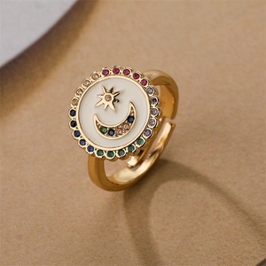 Detail of adjustable gold ring with white enamel moon star motif and colorful gems