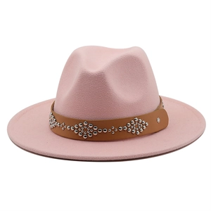 Close-up of pink wool felt hat featuring brown leather band with silver metal studs
