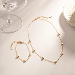 Detail view of gold titanium steel jewelry set with circular zircon stones and lobster clasp
