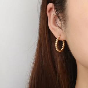 Polished gold plated titanium steel O-shaped hoop earrings with twisted geometric design