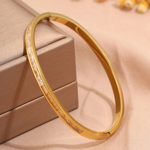 Detailed close-up of golden titanium steel bangle with rectangular cubic zirconia inlay