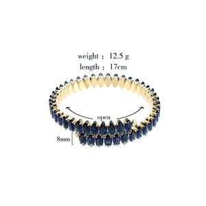Detail view of a 17cm gold marquise-cut blue gemstone open bangle with product dimensions