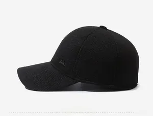 Side view of black baseball cap with twill texture and mountain metal logo detail
