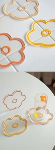 Close-up of flower-shaped acrylic coasters in vibrant orange and yellow floral patterns