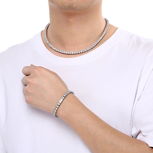 Gros plan d'un ensemble collier et bracelet tennis en zircone argentée sur un mannequin homme