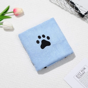 Detail of soft sky blue coral fleece pet towel featuring a black paw embroidery