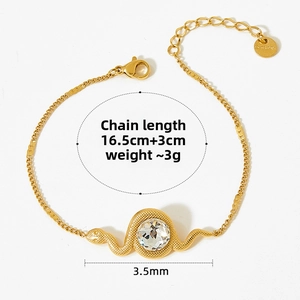 Detailed macro view of gold snake-shaped stainless steel bracelet with clear crystal stone