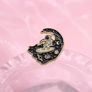 Cartoon astronaut on skateboard enamel pin with golden stars and moon on glass base