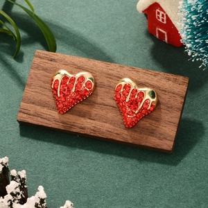 Detail shot of vintage gold heart earrings with red zircon in a festive Christmas setup