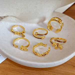 Macro shot of gold-plated rings with horse and coin motifs in a white display tray