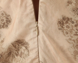 Détail de la fermeture éclair invisible et de l'imprimé floral marron sur tissu satiné