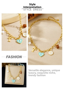 Détail du collier en chaîne dorée avec cœur émaillé, lettre T et pendentifs perles