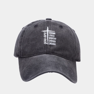 Detailed view of washed charcoal cotton baseball cap with white cross and motivational text