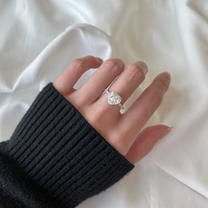 Close-up of S925 silver ring featuring a heart-shaped pink zircon worn on a finger