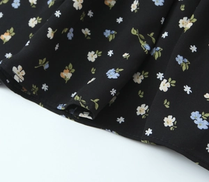 Close-up of floral print fabric on a black summer dress with detailed stitching