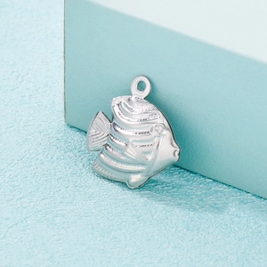 Macro detail of a silver stainless steel tropical fish pendant with fine textures