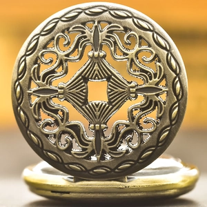 Macro shot of vintage bronze pocket watch featuring intricate hollow-out floral carving