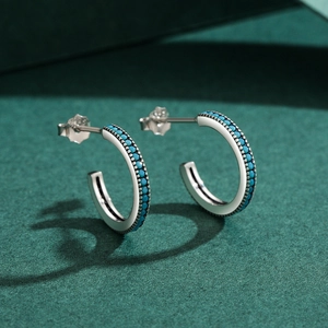 Elegant S925 sterling silver hoop earrings set with turquoise beads on dark green background