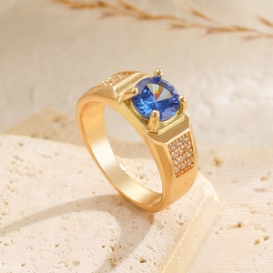 Makroaufnahme des Herrenrings in Gold mit blauem Zirkon und seitlichem Mikro-Pavé-Besatz