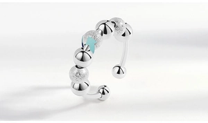 Detail view of silver anxiety ring with rotating polished and frosted beads on white background