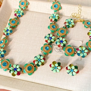 Detailed flat lay of vintage flower necklace and jewelry set with colorful rhinestones