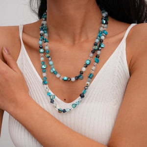 Close-up of bohemian layered beaded necklace with blue crystal and shell beads for women
