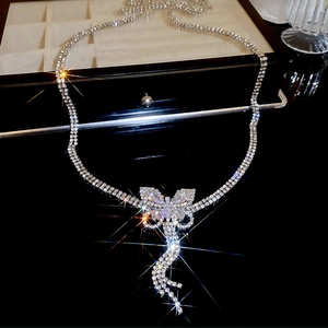 Macro detail of silver butterfly pendant with sparkling crystals and tassel chain fringes