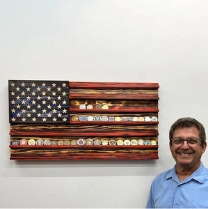 Detail of wall-mounted wooden American flag challenge coin display rack with 5 shelves