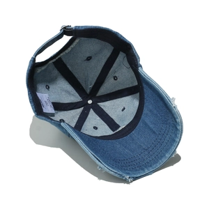 Internal view of denim baseball cap showing sweatband and distressed fabric edges