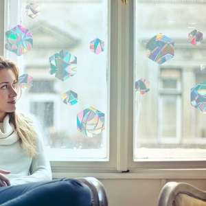 Detailed view of hexagonal prism window films casting rainbow light on glass surfaces