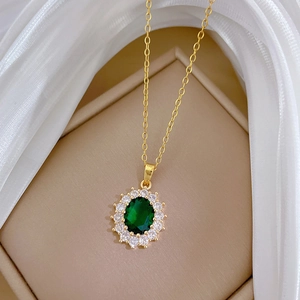 Elegant gold titanium steel necklace featuring an oval emerald green gemstone with crystals